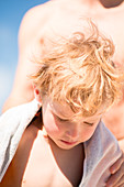 Young boy dries off after swim