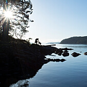 Man descends coastal rocks with dog