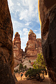 A woman walks between sandstone towers at The Doll House in Canyonlands National Park, Utah.