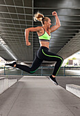 Fit Woman In A Sprint Run Jump Wearing Sports Bra