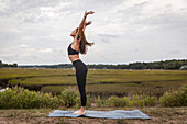 Frau über eine Vorwärtsfalte Vinyasa Flow Outside Auf Ein Yoga Mat