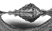 Mountains reflected in lake from shore, B&W