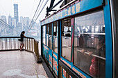 'Cable car crossing Yangtze river in Chongqing, the city as background covered by the fog; Chongqing, China'