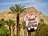 'Sign for Rancho Super Car wash beside palm trees and an arid landscape; Palm Springs, California, United States of America'