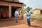 Ein Fotograf mit Kamera steht außerhalb eines Foto-Studio-Gebäude: Uganda