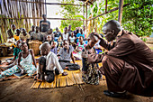 'Ein Pfarrer betet für ein kleines Kind; Gulu, Uganda'
