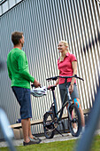 Man and woman on eBikes, City, Munich, Bavaria, Germany