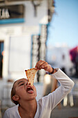 young girl eating a slice of pizza,  Conil de la Frontera, andalusia, southwest coast spain, atlantc, Europe