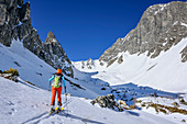 Woman backcountry skiing ascending through Hoellkar, Weisseck in background, Hoellkar, Felskarspitze, Radstadt Tauern, Carinthia, Austria