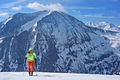 Woman backcountry skiing ascending towards Grosses Mosermandl, Weisseck in background, Grosses Mosermandl, Radstadt Tauern, Carinthia, Austria