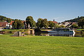 Blick vom Zeltplatz, Campingplatz auf die Weser mit einem kleinen Personen- Fährschiff am Pier vor Bad Karlshafen mit Pegelhaus, Bad Karlshafen, Hessen, Deutschland, Europa