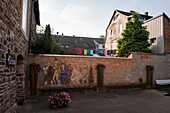 In the backyard to the Huguenot museum, painting on stone wall shows the Huguenots, Bad Karlshafen, Hesse, Germany, Europe