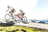 Two young people on their racing cycles in the Kitzbühler Alps, Kitzbühlerhorn, Tyrol, Austria