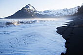 Wellen, die auf den Strand entlang der Küste entlang der Kenai Berge, Kachemak Bay State Park, Alaska, Vereinigte Staaten von Amerika