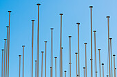 A accumulation of flagpoles in front of blue sky, Lisbon, Portugal