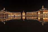 Place de la Bourse spiegelt sich im Miroir d’eau bei Nacht, Bordeaux, Gironde, Nouvelle-Aquitaine, Frankreich, Europa