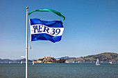 Pier 39 flag in front of Alcatraz, San Francisco, California, USA