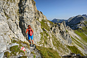 Woman hiking ascending towards Weissgrubenkopf, Weissgrubenkopf, valley Riedingtal, Radstadt Tauern, Lower Tauern, Carinthia, Austria