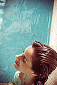 Woman on vacation relaxing by side of pool