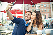 Couple posing for a selfie at outdoor cafe