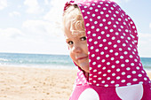 Mädchen trägt Kapuze mit Polka Dots am Strand