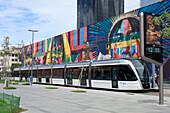 The new Rio de Janeiro VLT tram in front of a mural by Kobra in the Porto Maravilha port area, Rio de Janeiro, Brazil, South America