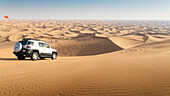 Off road vehicle on sand dunes near Dubai in the United Arab Emirates, Middle East