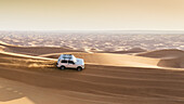 Offroad-Fahrzeug auf Sanddünen in der Nähe von Dubai, Vereinigte Arabische Emirate, im Nahen Osten