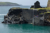 Coasteering activity with people jumping from the former quarry building at the Abereiddy blue lagoon, Pembrokeshire, Wales, United Kingdom, Europe