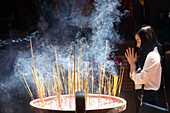 Buddhist worshipper burning incense sticks, Chua On Lang Taoist Temple, Ho Chi Minh City, Vietnam, Indochina, Southeast Asia, Asia