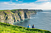 Couple admiring the landscape, Cliffs of Moher, Liscannor, Co, Clare, Munster province, Ireland