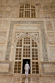 Agra, Uttar Pradesh, Indien, Ein Mann, der traditionelle weiße Kleidung trägt, geht in den Taj Mahal