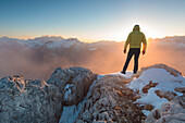 Europe, Italy, Veneto, Belluno, Agordino, Palazza Alta, Dolomites, Hiker on a mountain top admiring the sun setting
