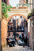 Junge Leute entspannen sich am Wasser, Venedig, Venetien, Italien