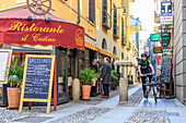 Urban bike messenger and delivery at work in the old town center of Milan Lombardy Italy Europe