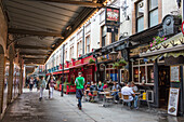 People walk in the pedestrian area with cafe and restaurants of Leicester Square Covent Garden Camden London United Kingdom