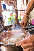Chef mix the ingredients for typical polenta, San Romerio Alp, Brusio, Canton of Graubünden, Poschiavo valley, Switzerland