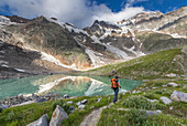 A girls walks near the Locce Lake at the foot of the East face of Monte Rosa Massif (Locce Lake, Macugnaga, Anzasca Valley, Verbano Cusio Ossola province, Piedmont, Italy, Europe)