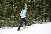 Woman snowshoeing in the woods.