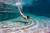 Underwater view of woman in swimming pool