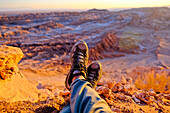 Hiker resting during sunset over Valle de La Luna in Atacama Desert outside of San Pedro de Atacama, Chile