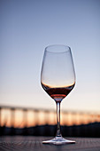Glass of red wine against clear sky at dusk, Delaplane, Virginia, USA