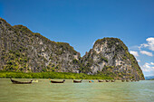 Boats floating in line by green cliffs, Phang Nga Bay, Phang Nga, Thailand
