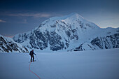 A ski mountaineer on the lower Kahiltna glacier of Denali National Park in Alaska, with mount Foraker in the background.