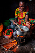In ihrem Haus in der Nähe von Arusha bereitet Tanzania Solar Schwester Unternehmerin Julieth Mollel ein Abendessen mit Ugali, Gemüse und Bohnen auf ihrem sauberen Kochherd zu. Ugali ist ein Grundnahrungsmittel, das in vielen Ländern Afrikas gegessen wird 
