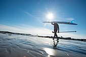 Paddleboarder Heading Into The Cold Atlantic Waters On A Sunny Day