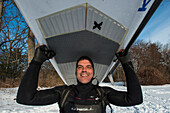 Porträt des lächelnden Paddleboarder Carrying Paddleboard vor der Küste von Maine