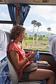 Girl Texting In Her Smartphone While Sitting On A Bus In Cuba