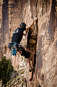 Tyler Price climbs a route in the sandstone of Buckhorn Wash in the San Rafael Swell, Utah.