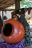 Two women decorate giant pot at Bagan House Lacquerware Workshop, New Bagan, Bagan, Mandalay, Myanmar